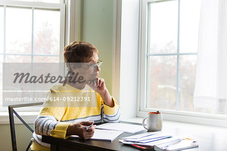 Senior woman thinking at desk