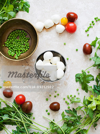 Still life of bowls of mozzarella cheese and peas with tomatoes and parsley