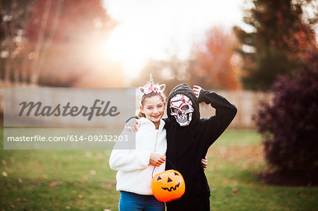 Siblings in halloween costume posing in park