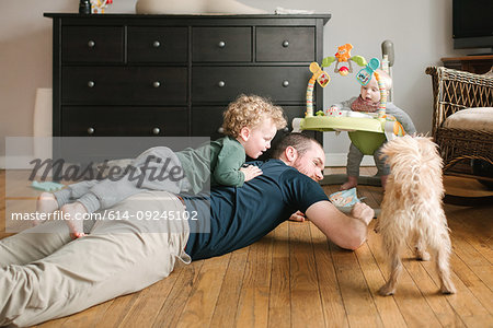 Father and son playing, pet dog joining in