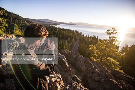 Man taking photographs at sunrise, Lake Tahoe, Tahoe City, California, United States