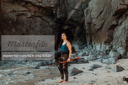 Woman with flippers and speargun on beach, Big Sur, California, United States