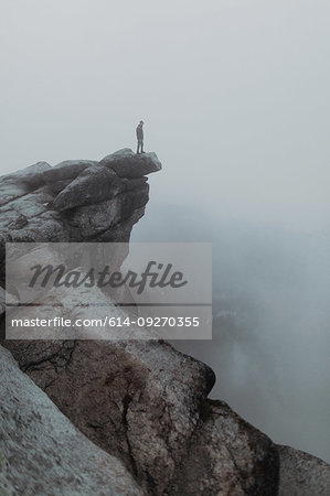 Hiker enjoying view of fog covering valley, Yosemite National Park, California, United States