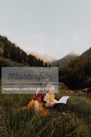 Female toddler sitting on mother's lap by rural river, portrait, Mineral King, California, USA