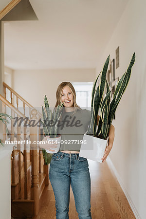 Woman carrying large and small pots of house plant