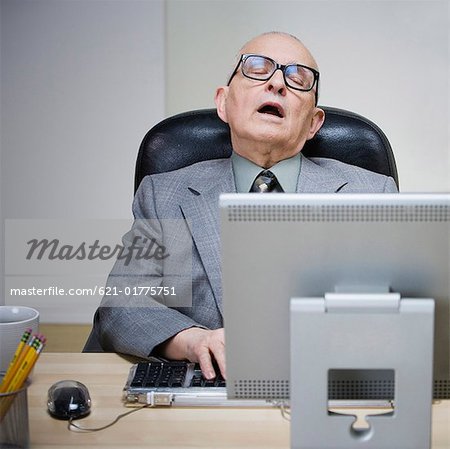 Senior Man Sleeping At Desk Stock Photo Masterfile Premium