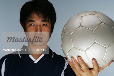 Determined soccer player holding ball