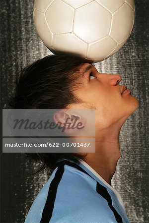 Soccer player balancing ball on head