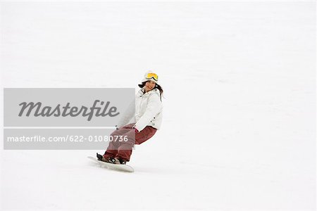 Young Asian snowboarder in action