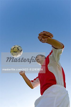 Boy juggling Soccer ball