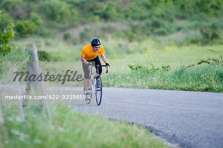 Front view of a man cycling on road