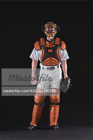 A baseball catcher standing with ball