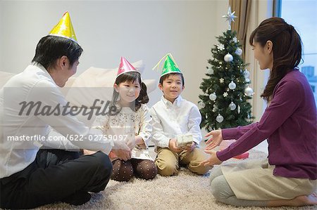 Family wearing party hats with birthday present