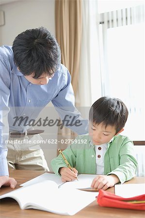 Japanese boy doing homework with his father