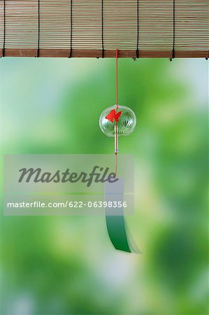 Wind chime and green maple leaves
