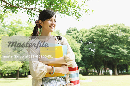 Female college student in a park smiling away