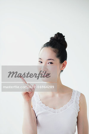 Young woman pointing finger up smiling