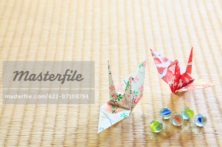 Origami cranes and marbles on tatami mat