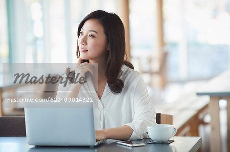 Japanese woman with laptop in a stylish cafe