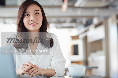 Japanese woman with laptop in a stylish cafe