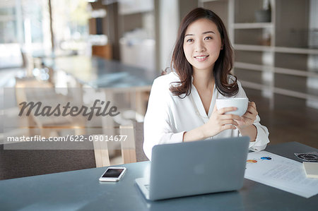 Japanese woman with laptop in a stylish cafe