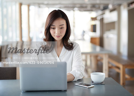 Japanese woman with laptop in a stylish cafe