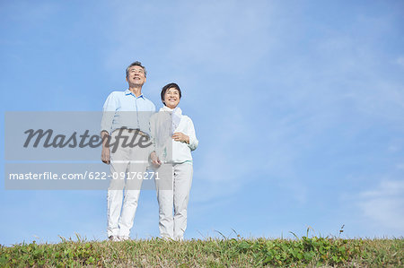 Japanese senior couple having fun by the sea