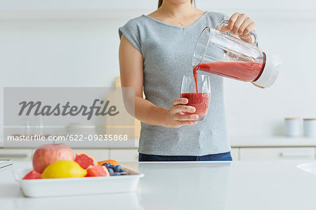 Japanese woman making smoothie in the kitchen