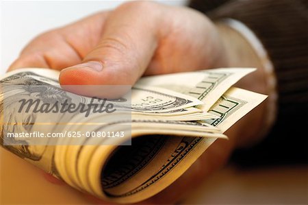Businessman holding United States one hundred dollar bills, close- up