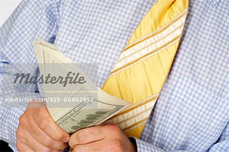 Mid section view of a businessman holding paper currency