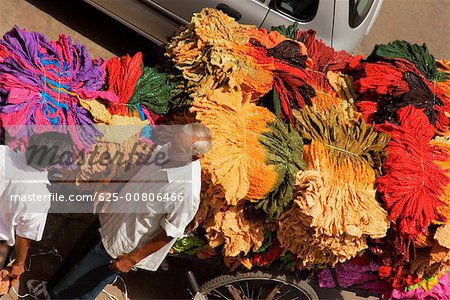 High angle view of a senior man and a mid adult man standing near a cart loaded with clothes