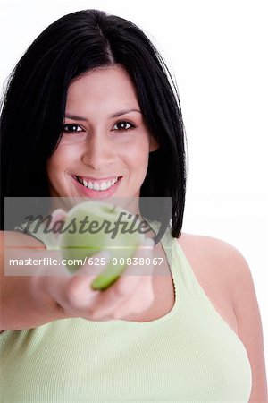 Portrait of a young woman holding a green apple