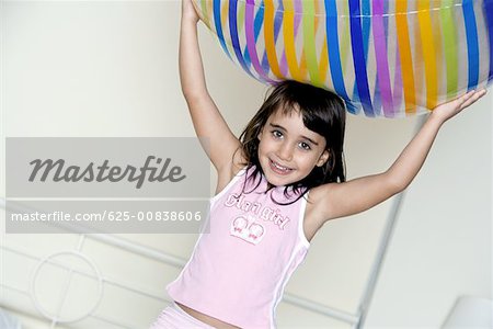 Close-up of a girl holding a large inflatable ball over her head