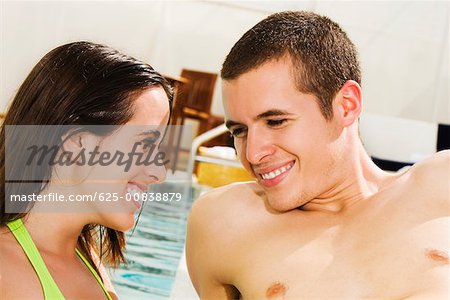 Close-up of a young couple smiling at the poolside