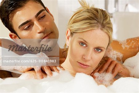 Portrait of a young man massaging a young woman in a bathtub