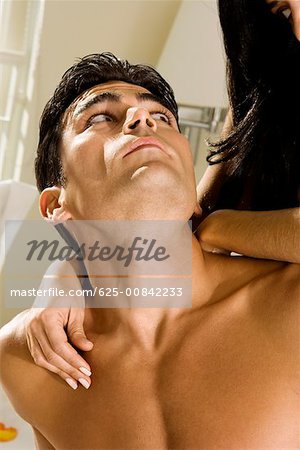 Mid adult couple looking at each other on the bed