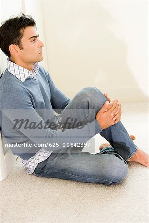 Side profile of a mid adult man sitting on the floor