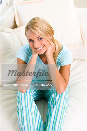 High angle view of a young woman sitting on a bed