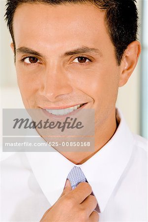 Portrait of a businessman adjusting his tie