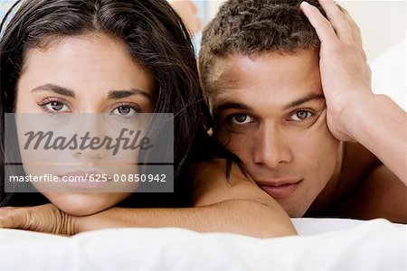 Portrait of a young couple lying on a bed