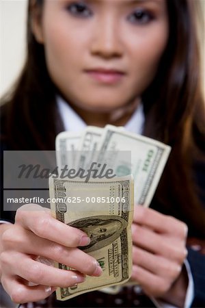 Portrait of a businesswoman holding one hundred dollar bills