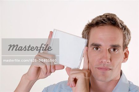 Portrait of a mid adult man holding a CD case