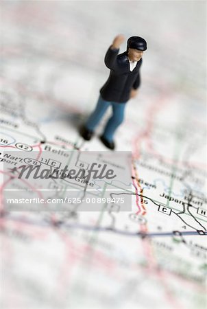 High angle view of a human figurine on a road map