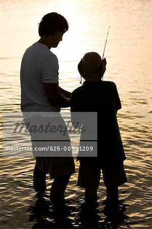 Father son silhouette fishing Stock Photos - Page 1 : Masterfile