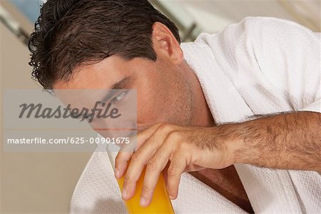 Close-up of a mid adult man drinking a glass of juice