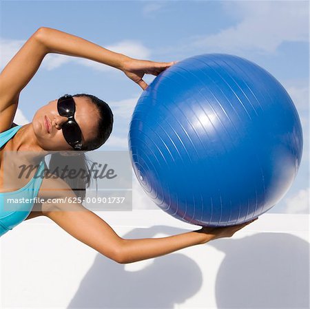 Young woman exercising with a fitness ball