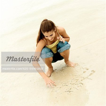 High angle view of a girl playing tic-tac-toe on the beach