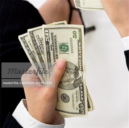 Close-up of a businesswoman's hand holding American dollar bills