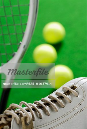 Close-up of a tennis shoe with a tennis racket