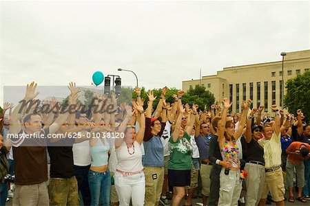 Large group of people waving their arms at a gay parade